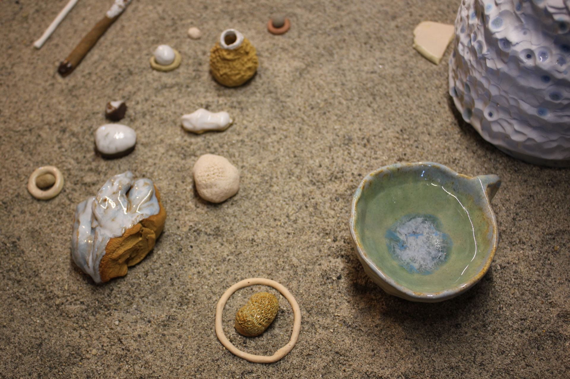 Assortment of abstract ceramic forms in sand