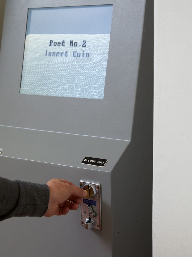 A close-up of a person inserting a coin into an ATM machine, through a slot. In the background the ATM screen reads "poet number 2 insert coin".