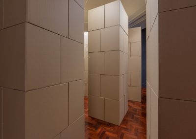 A room filled with vertical stacks of cardboard boxes, arranged into tall towers.
